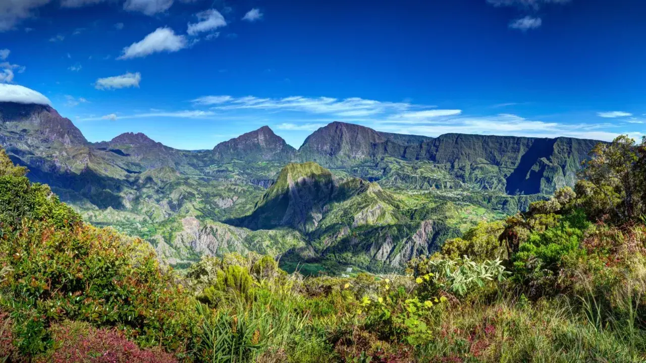 Paysage montagneux verdoyant sous un ciel bleu. Idéal pour réfléchir à que faire à la Réunion.