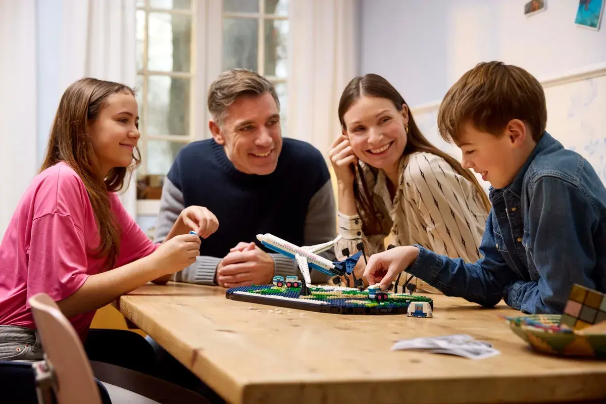Familie baut gemeinsam ein Flugzeugmodell. Die Faszination LEGO verbindet Jung und Alt.