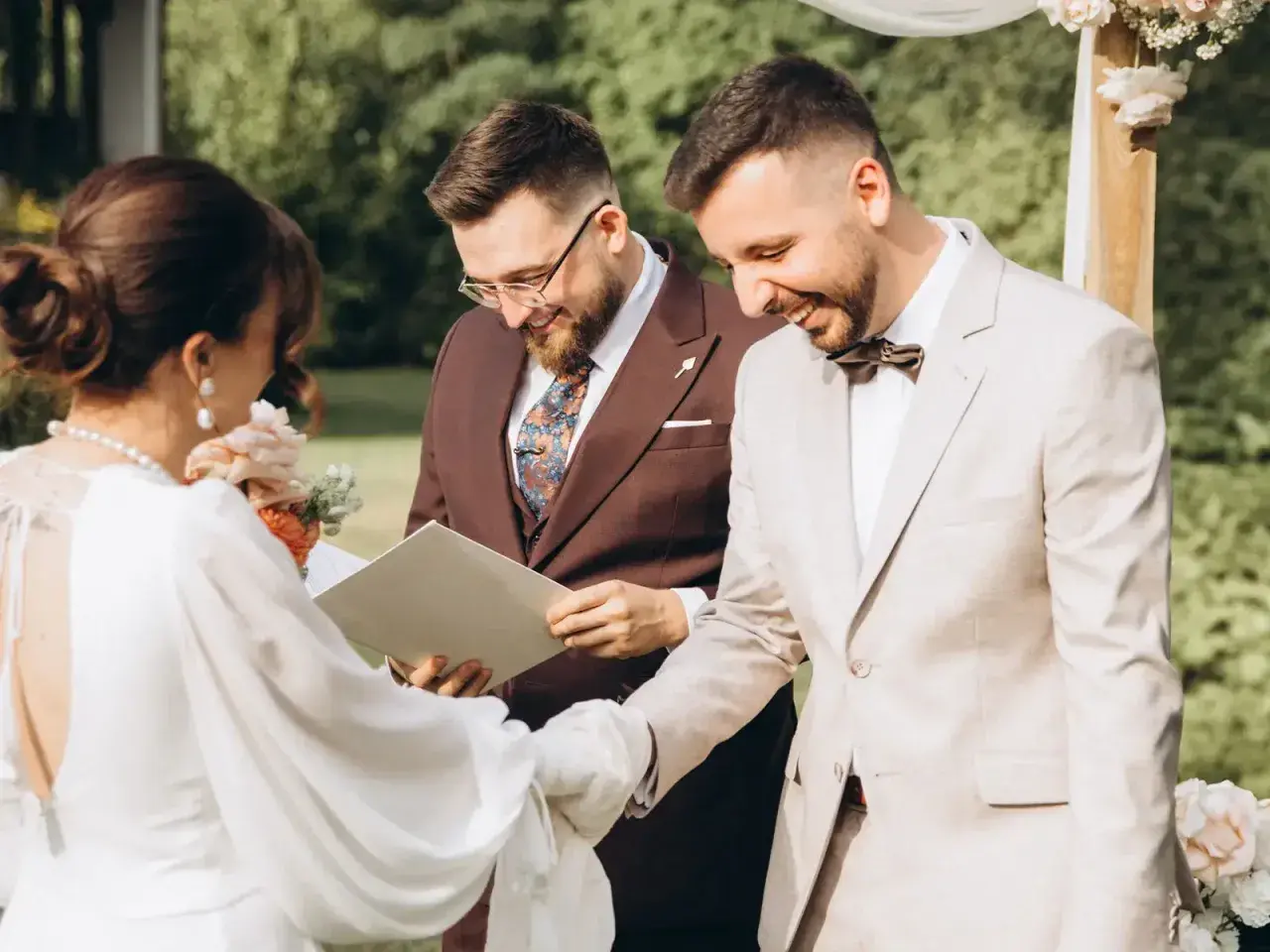 Uroczystość ślubu cywilnego, podczas której para młoda wymienia obrączki. W tle urzędnik udzielający ślubu.