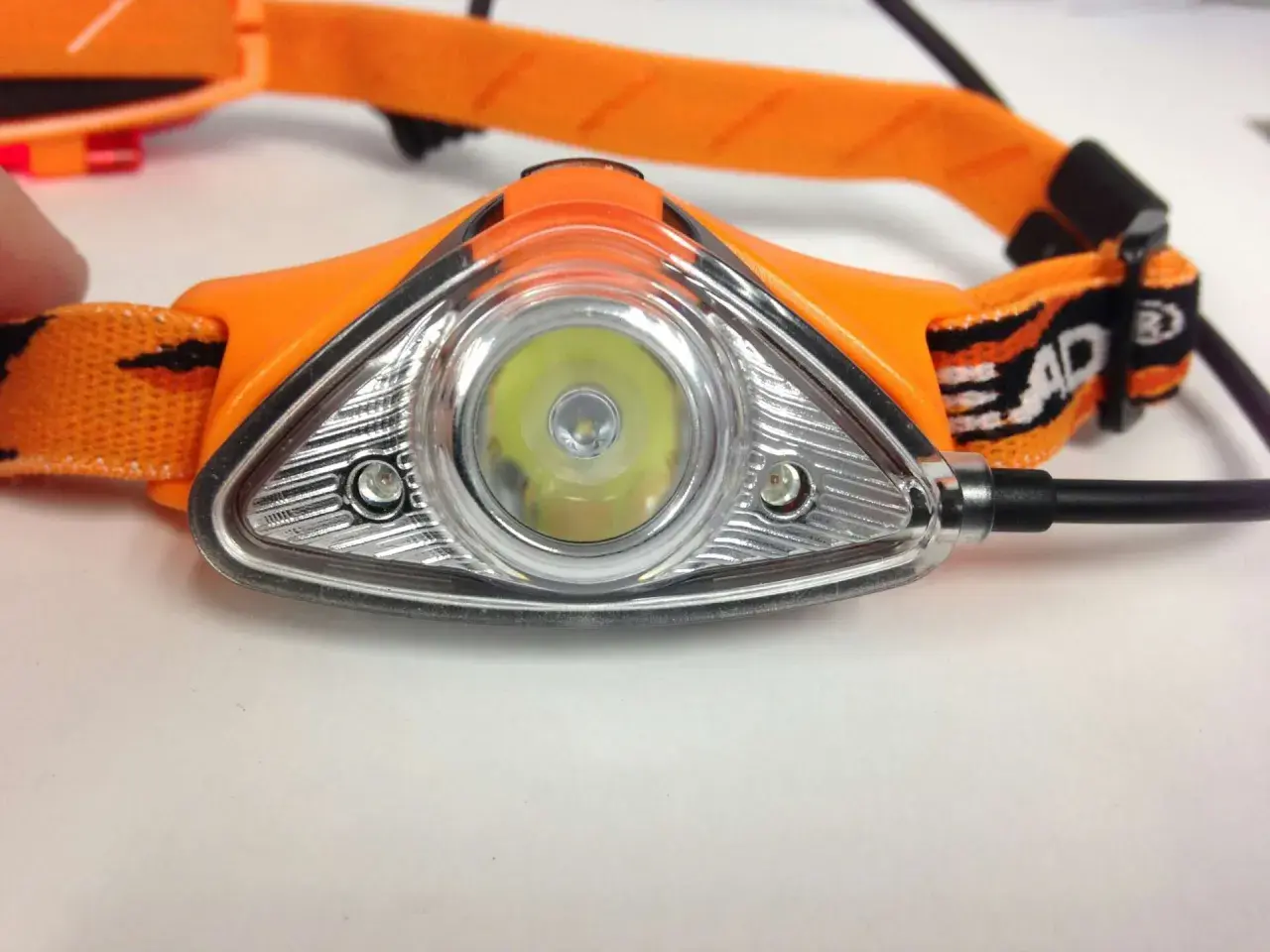 Orange Stirnlampe mit hellem LED-Licht, ein unverzichtbares Gadget für Nachtwanderungen.