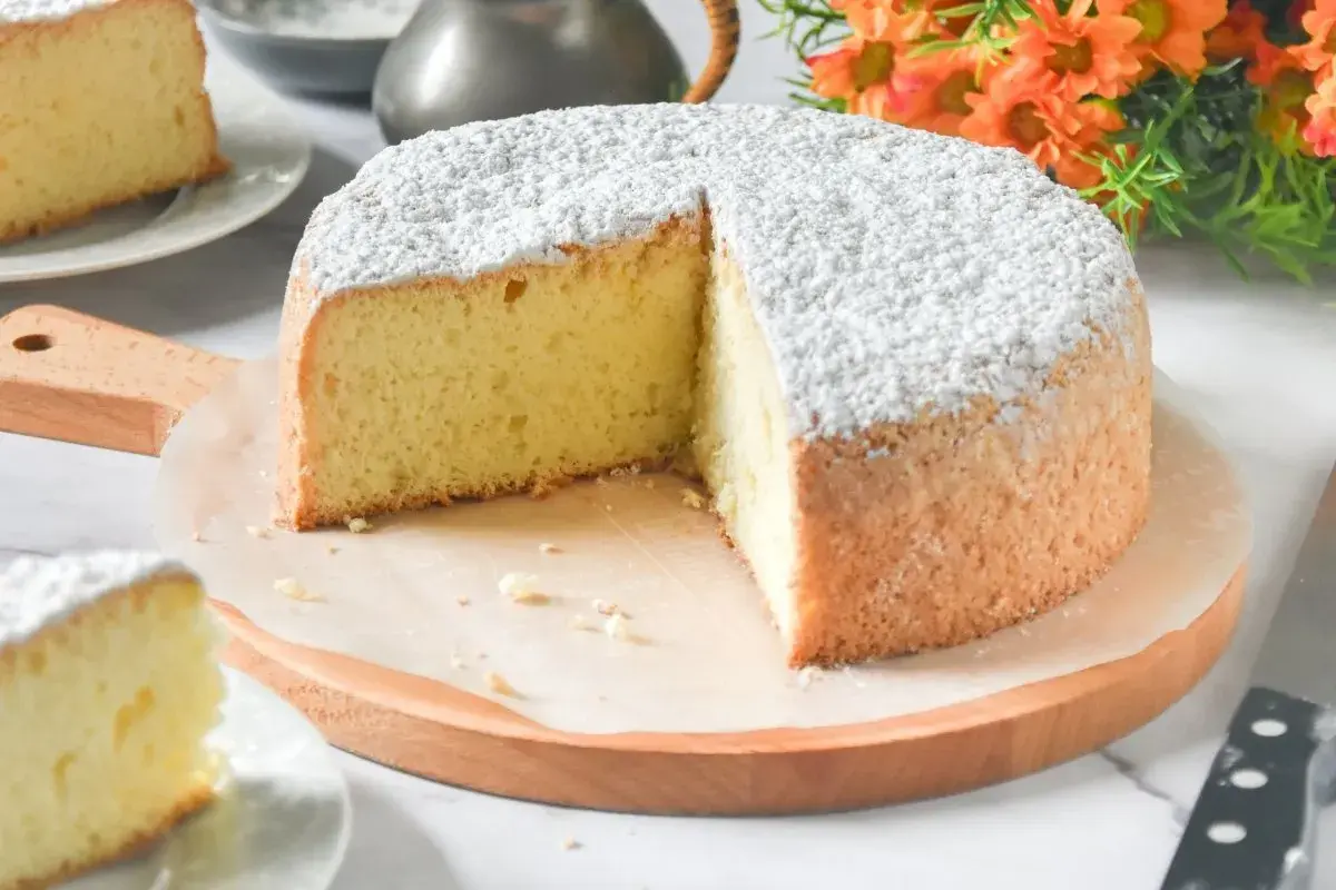 Un delicioso pa de pessic, esponjoso y cubierto de azúcar glas, listo para ser disfrutado.