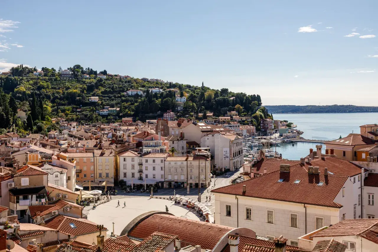 Piran: malerische Altstadt mit roten Dächern, Hafen und grünen Hügeln. Entdecken Sie Piran Geheimtipps für Ihren Urlaub.
