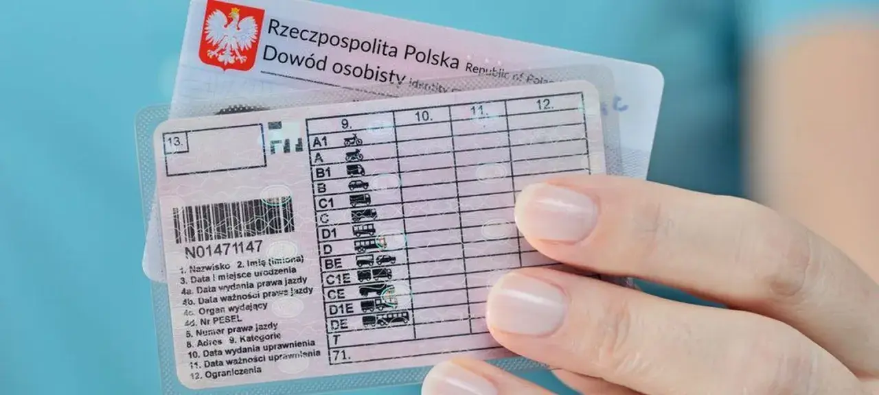 Dłoń trzyma polskie prawo jazdy z widocznymi kategoriami pojazdów, od motocykli po autobusy.