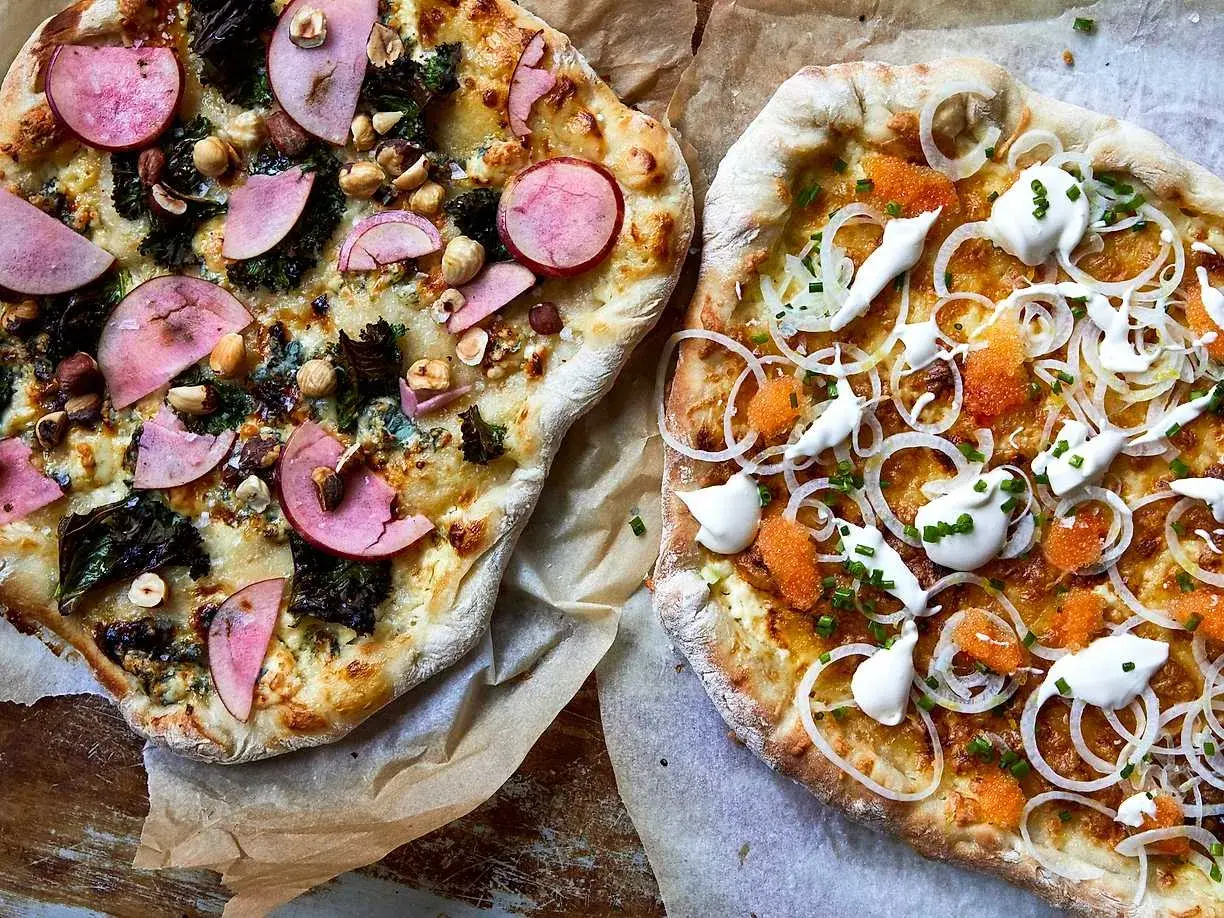 Två läckra pizzor, en med äpple och nötter, den andra en vit pizza med rom och gräddfil.