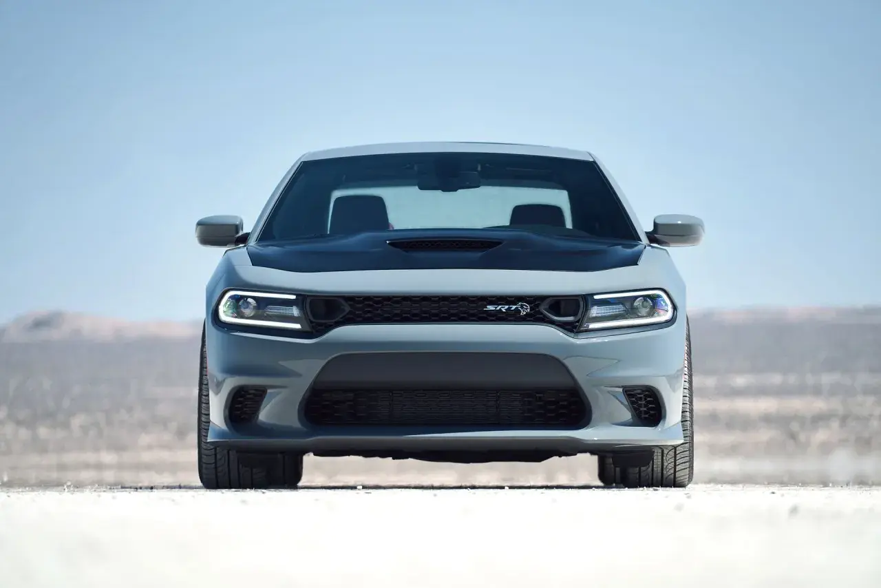 Szary Dodge Charger Hellcat z czarną maską i reflektorami LED na pustynnym tle.