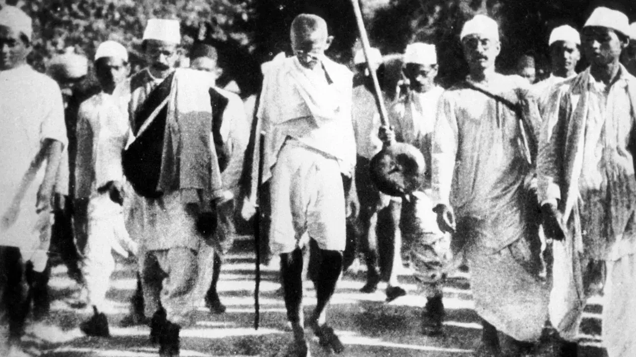 Mahatma Gandhi führt eine Gruppe von Menschen an, die sich auf einen Marsch vorbereiten.