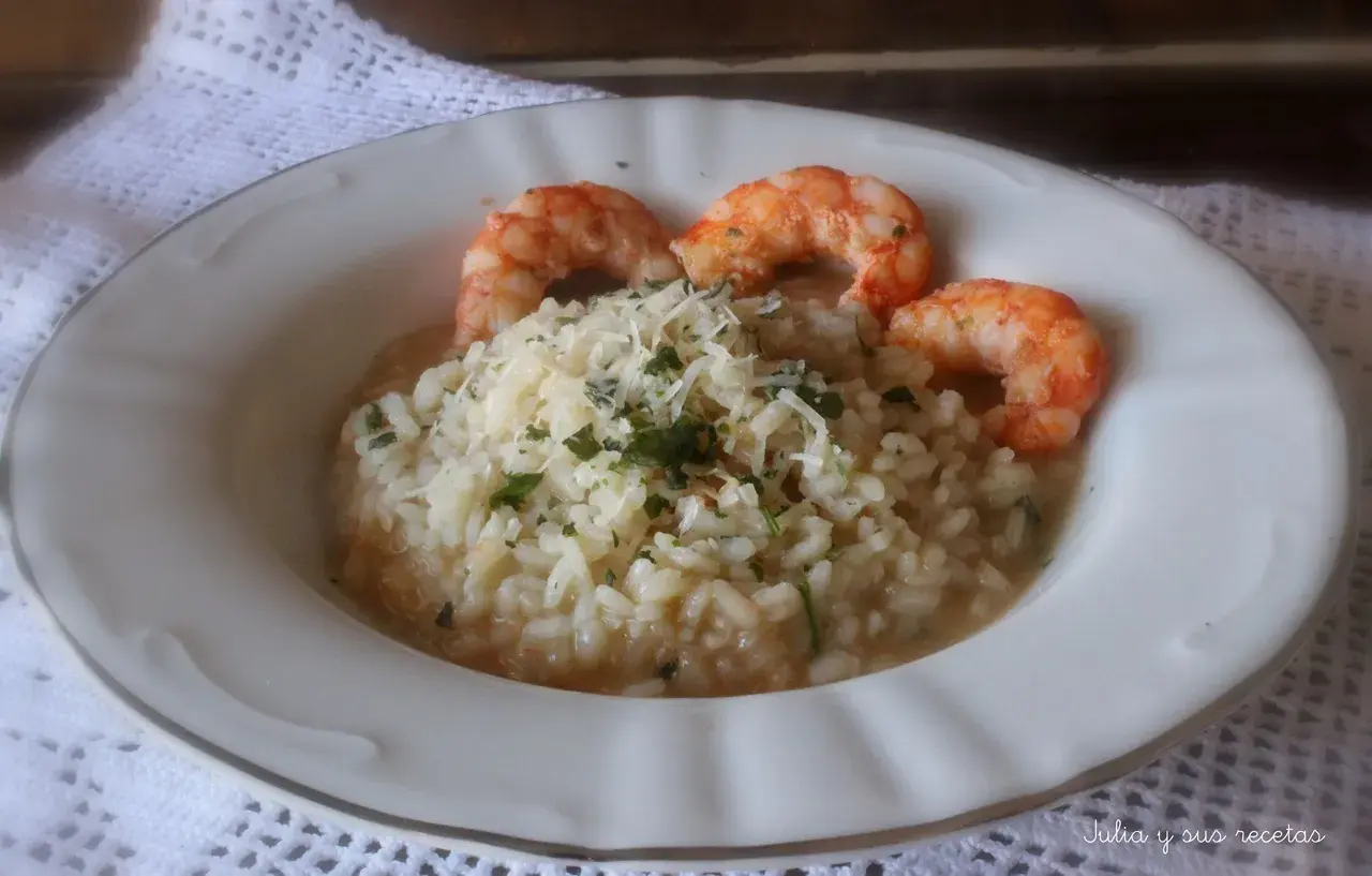 Delicioso risotto de langostinos cremoso, coronado con queso rallado y perejil fresco. Un plato principal que invita a disfrutar.
