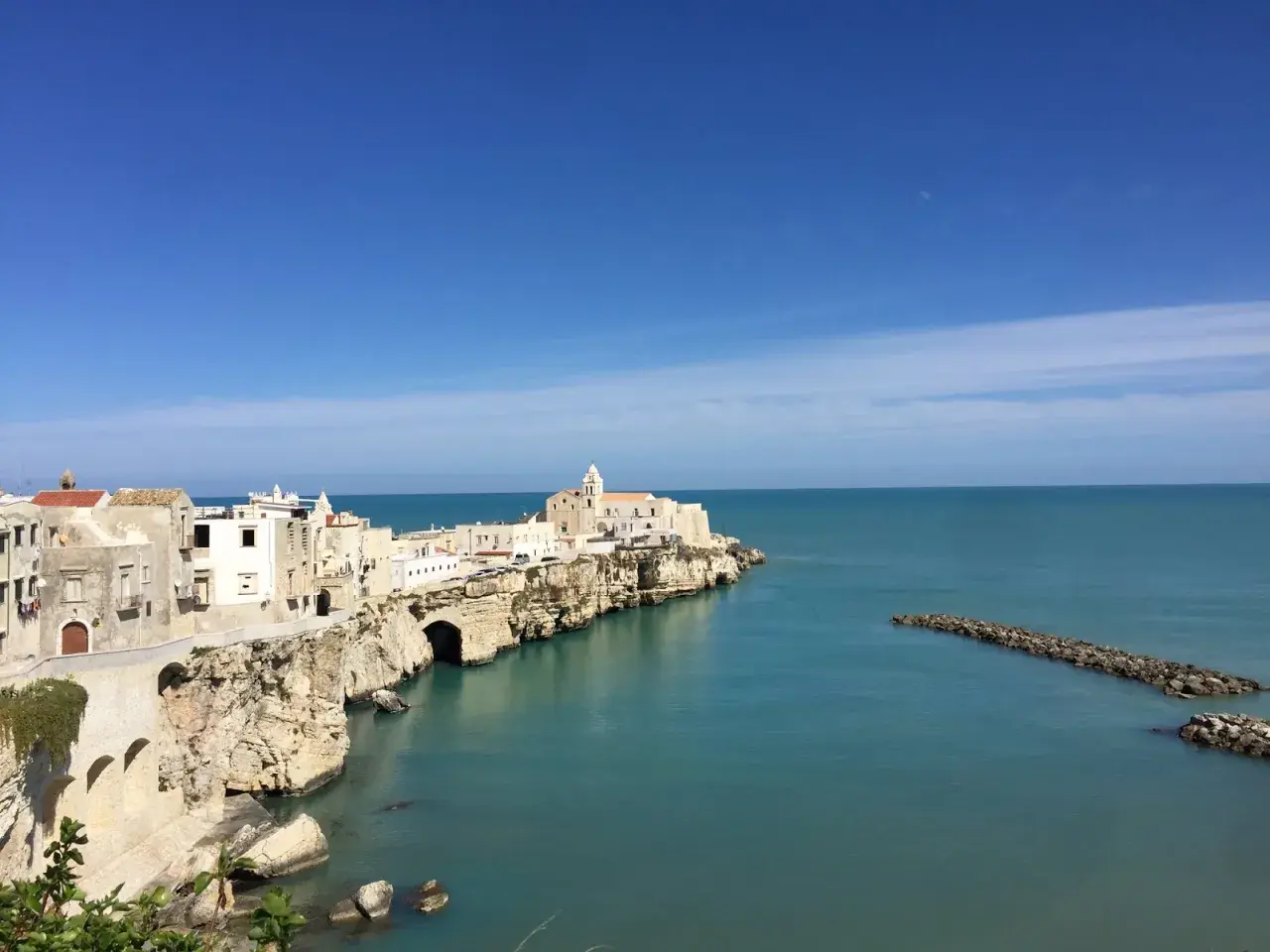 La piana della battaglia di Vieste, con le sue case bianche aggrappate alla roccia, si affaccia sul mare azzurro.