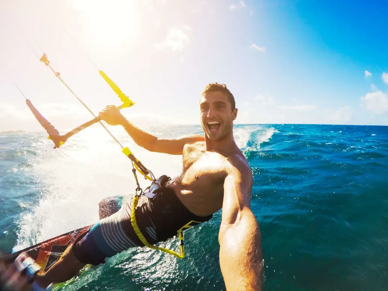 Szczęśliwy facet na kitesurfingu robi selfie. Wskazówka, jak zrobić dobre selfie facet: uśmiech i akcja!