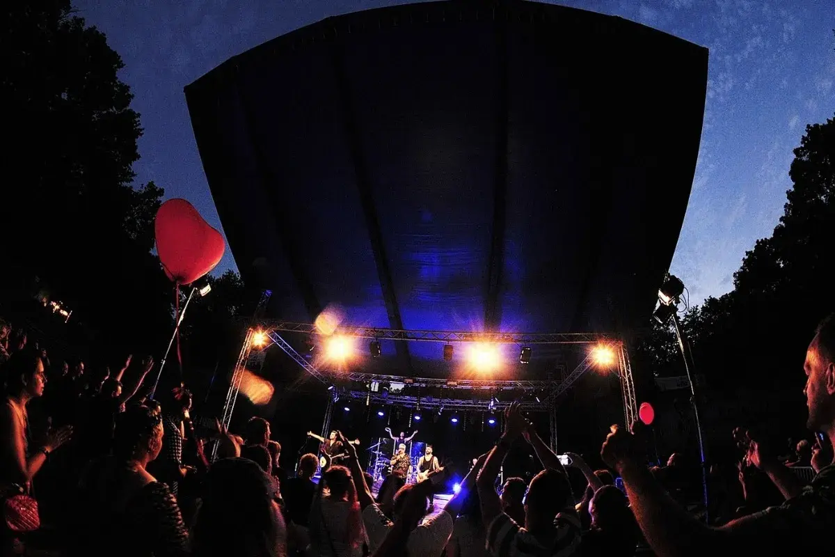 Koncert w amfiteatrze w Kołobrzegu. Tłum bawi się pod sceną, widać czerwone serce na balonie.