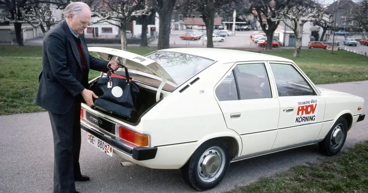 Äldre man lastar bagage i en vit Hyundai Pony. Bilen har texten "Teknikens Värld Provkörning" på sidan.