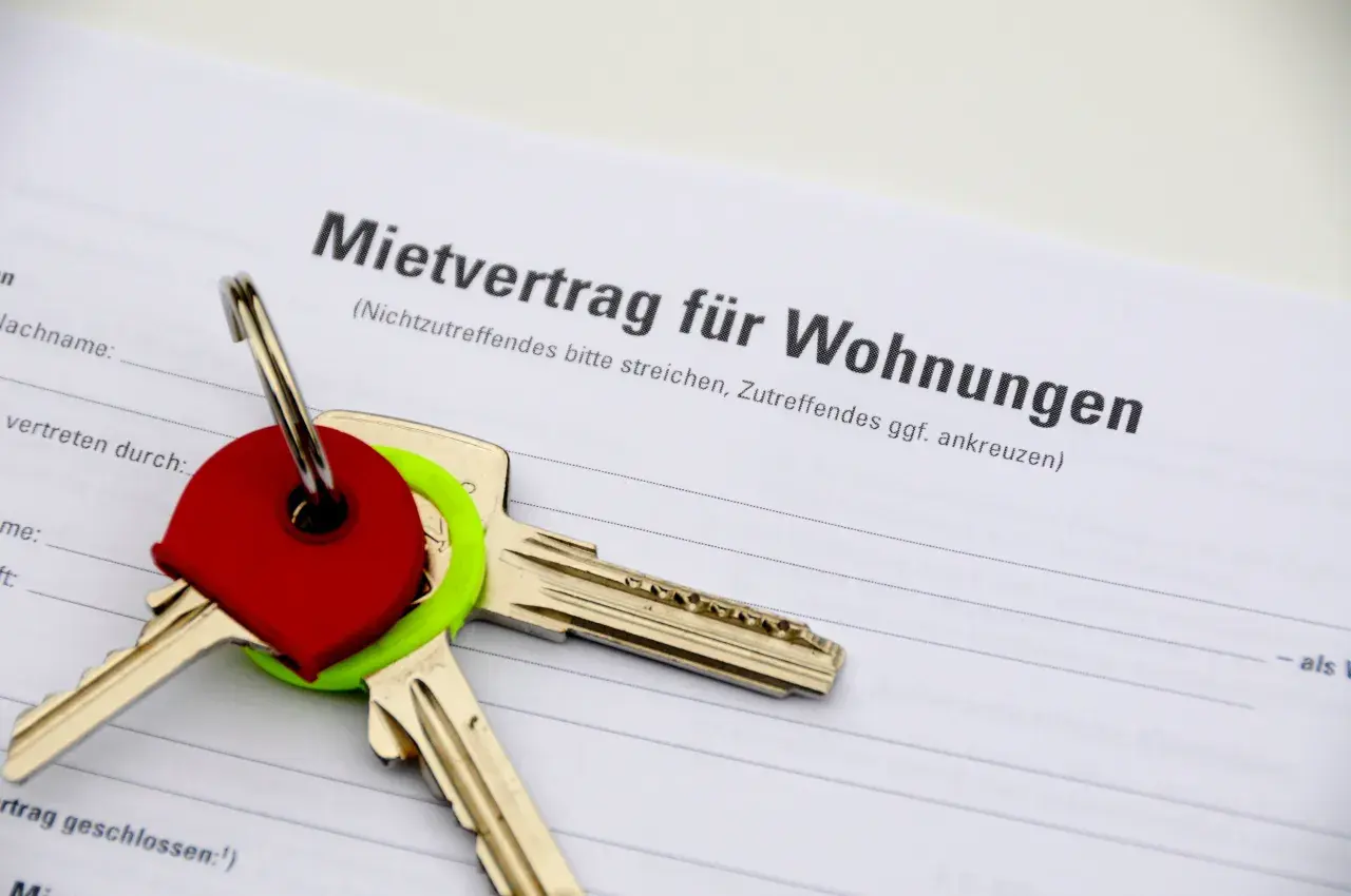 Schlüssel auf einem Mietvertrag. Der Vertrag ist für Wohnungen in Hamburg, und die Schlüssel symbolisieren den Einzug in ein neues Zuhause, vielleicht nach Prüfung des Betriebskostenspiegels Hamburg.