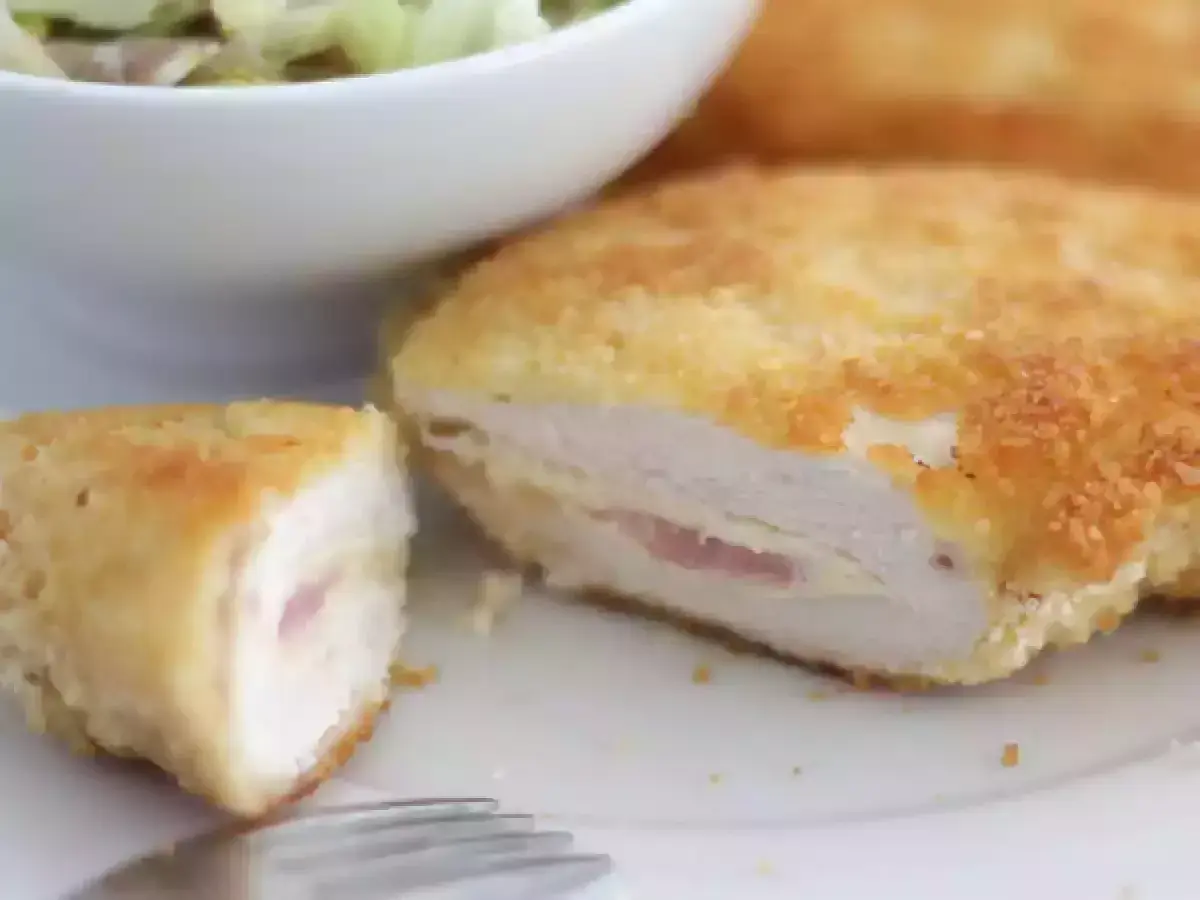 Un délicieux cordon bleu, pané et doré, révèle son cœur fondant de jambon et de fromage. Servi avec une salade verte.
