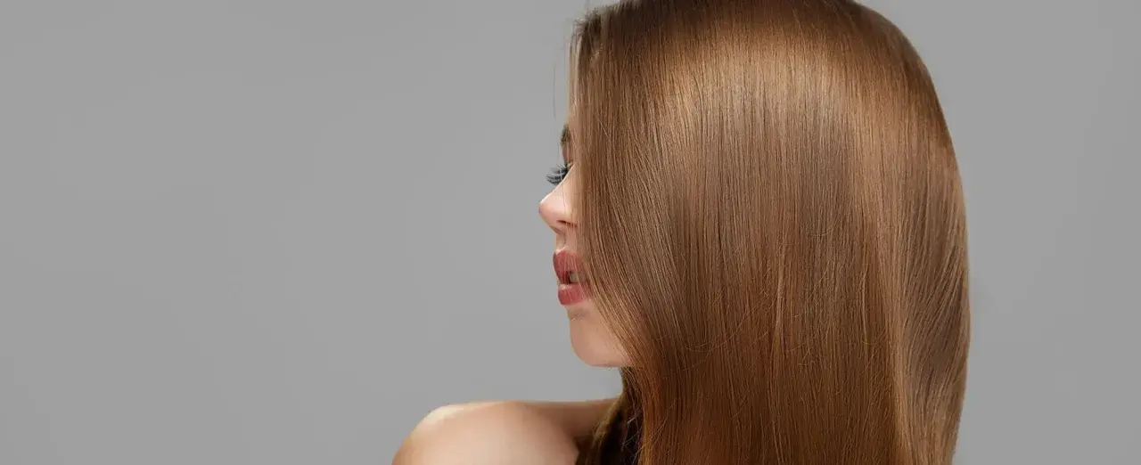 Perfil de mujer con cabello liso y sedoso de color de pelo castaño claro.