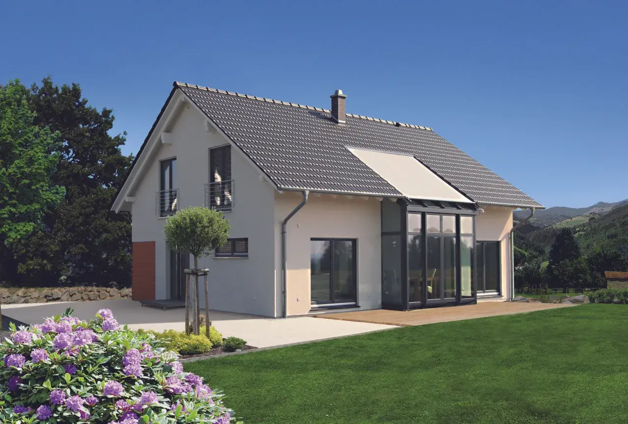 Modernes 1,5-geschossiges Haus mit Satteldach und Glasanbau. Der Grundriss bietet viel Licht und Raum.