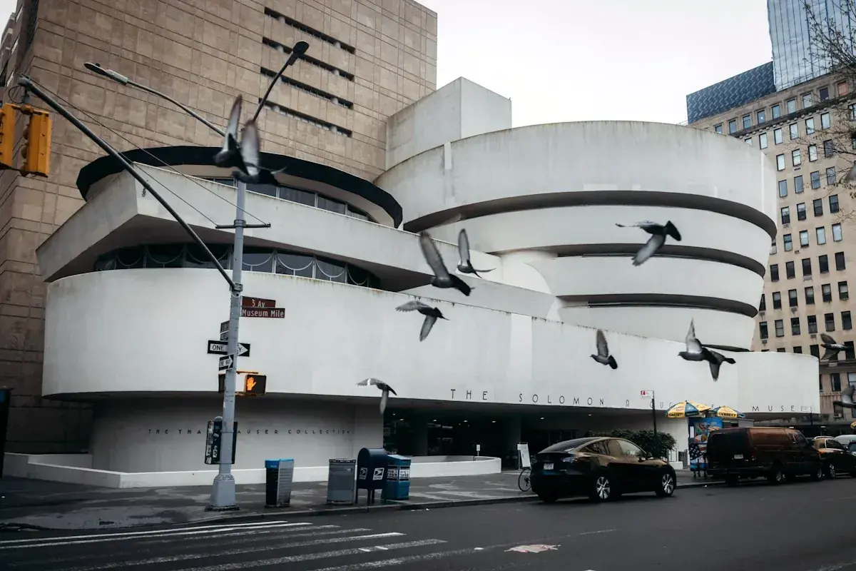 Duvor flyger framför den ikoniska spiralformade Guggenheim-byggnaden. Vem var Guggenheim? En visionär samlare som skapade detta arkitektoniska mästerverk.