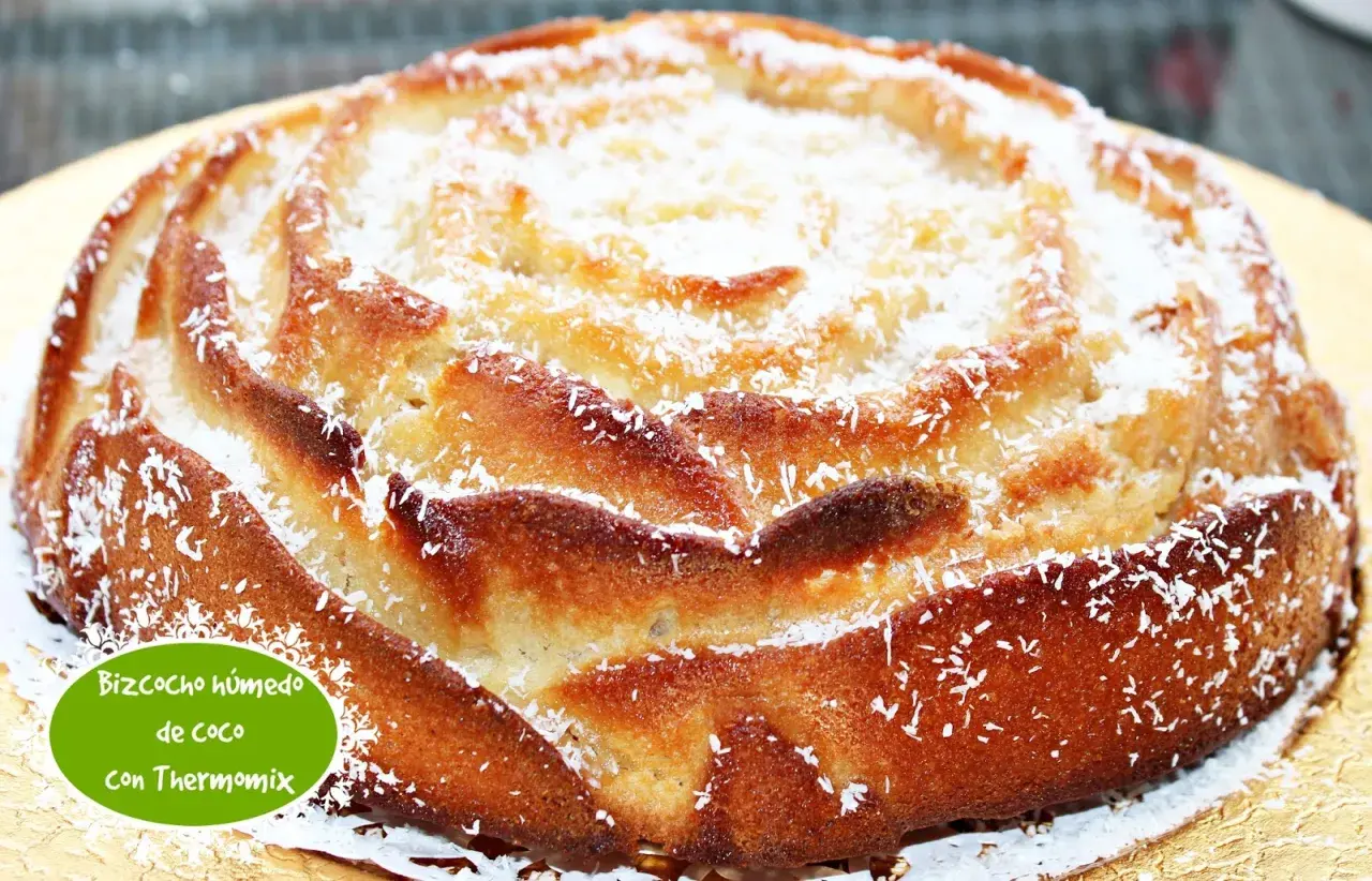 Bizcocho húmedo de coco, con una textura esponjosa y un delicioso aroma tropical, espolvoreado con coco rallado.