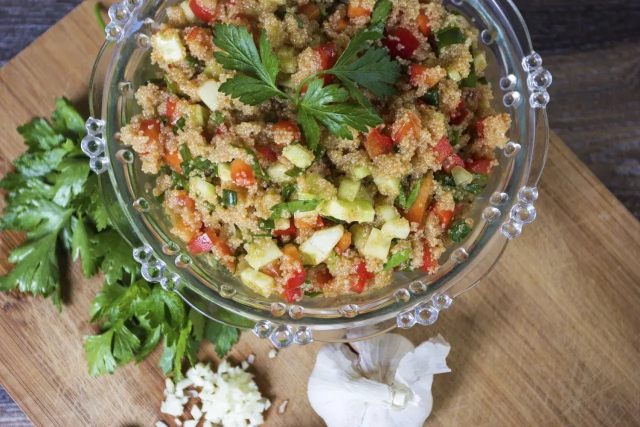 Insalata di amaranto colorata con pomodori, cetrioli e peperoni, guarnita con prezzemolo fresco.