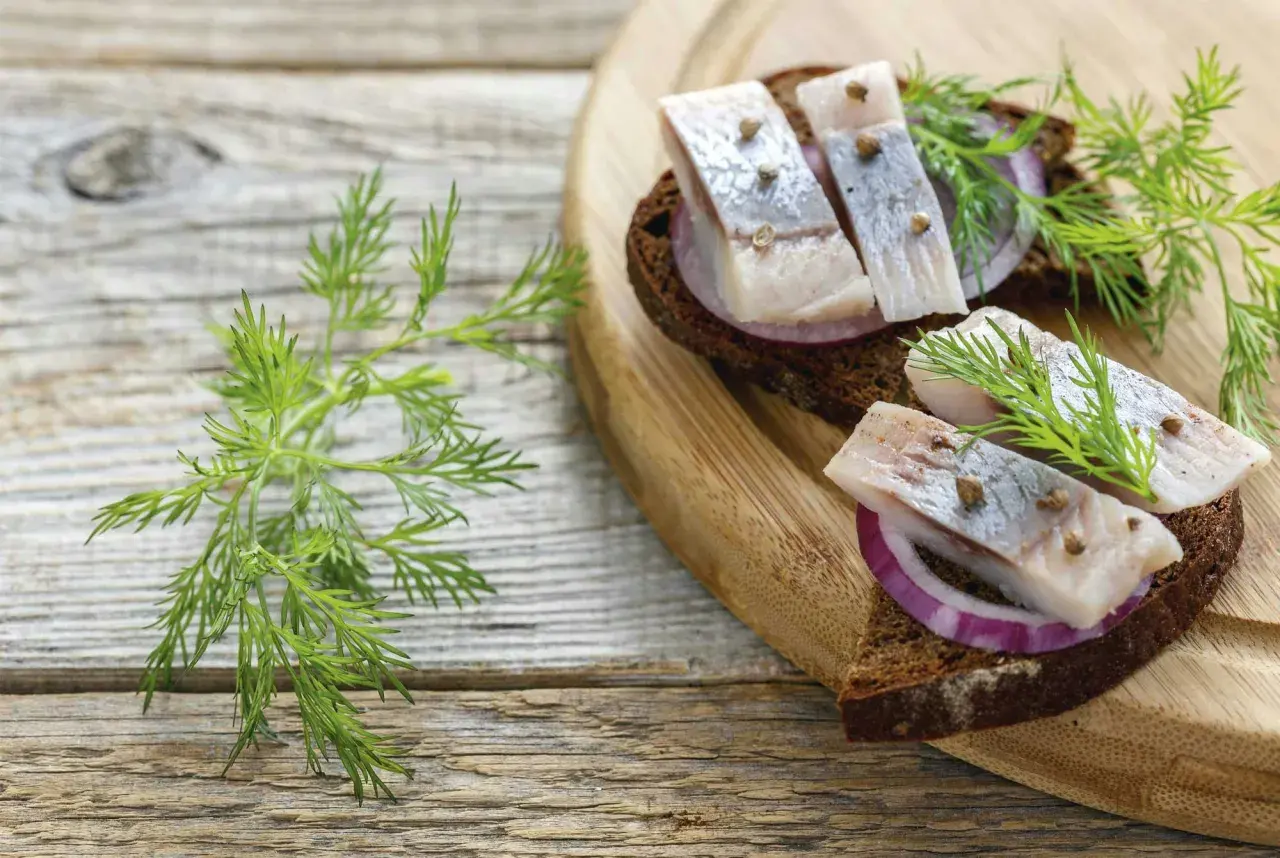 Smörgåsar med sill, rödlök och dill på mörkt bröd. Sill nyttigt och gott!