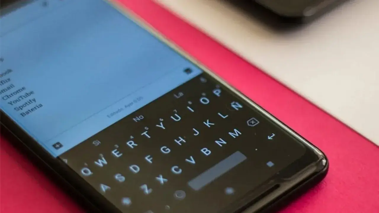 Pantalla de un smartphone con teclado QWERTY. Se busca cómo quitar vibración teclado para una experiencia más silenciosa.