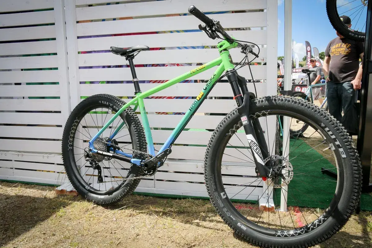 A green and blue gradient mountain bike, likely for a fat chance yo eddy review, with chunky tires and RockShox suspension.