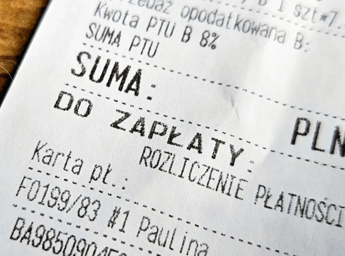 Fragment paragonu z napisem "SUMA: DO ZAPŁATY". Widoczna też kwota podatku i numer karty płatniczej. To faktura do paragonu.