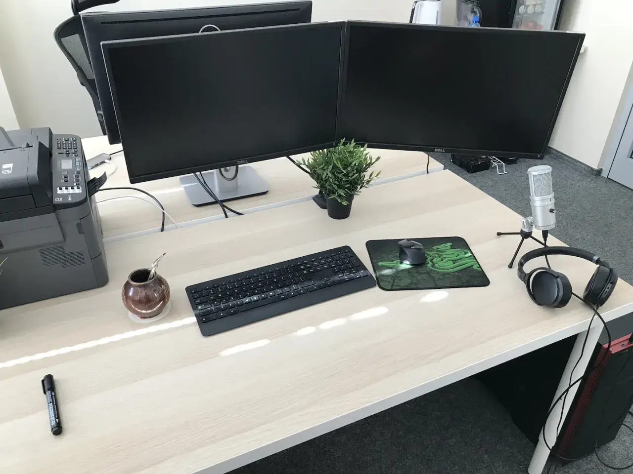 Biurko z dwoma monitorami, klawiaturą, myszką i słuchawkami. Idealne stanowisko do pracy jako programista.