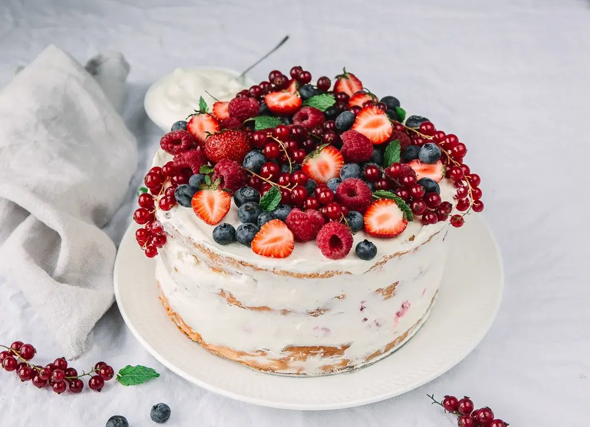 Himbeer Mascarpone Torte, üppig belegt mit frischen Beeren und Minze. Ein Fest für die Sinne!