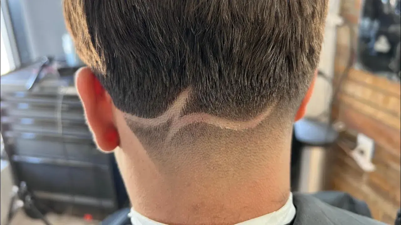 Corte de pelo con diseño en zig-zag y un taper fade impecable en la nuca.