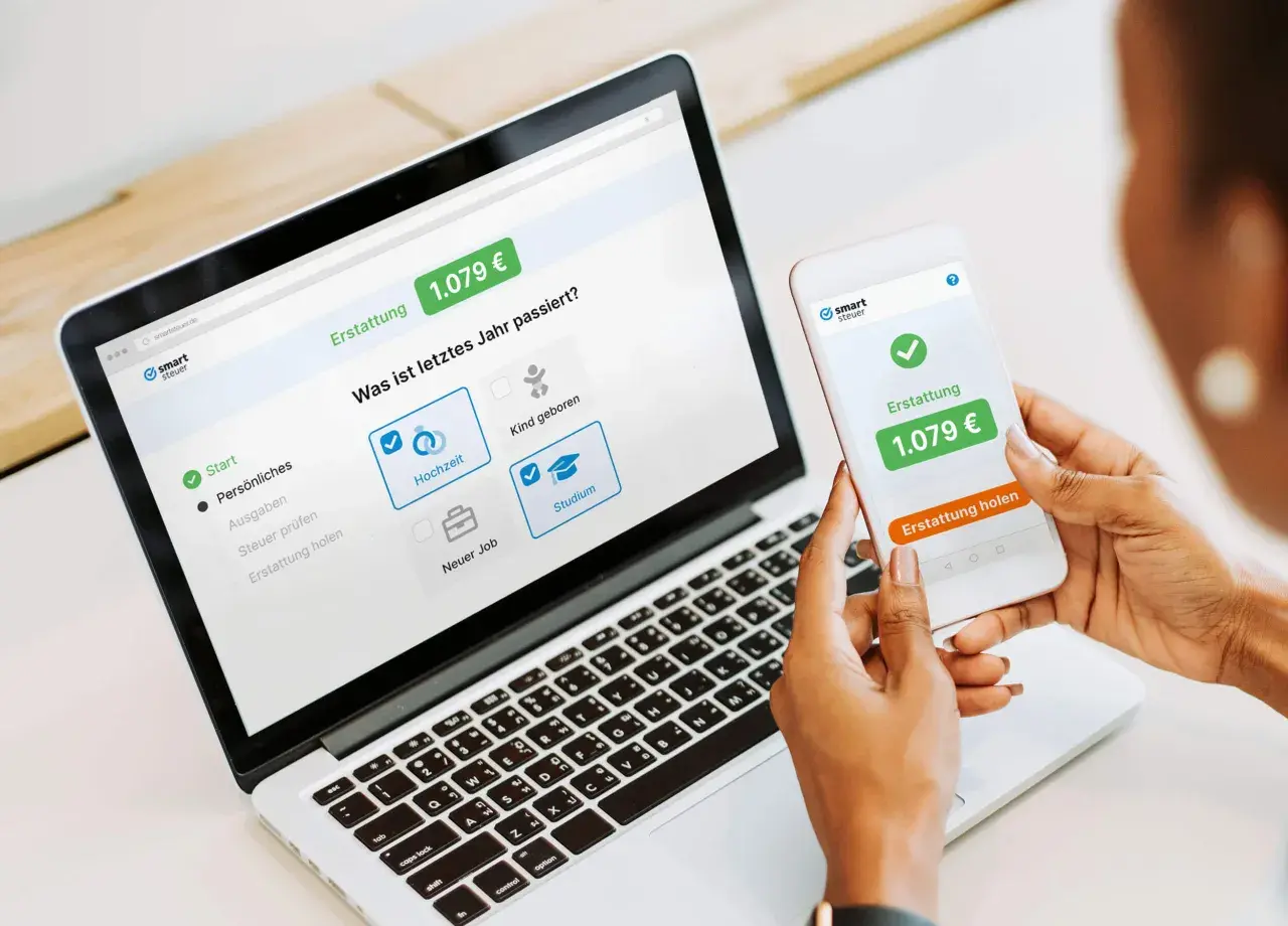 Eine Person nutzt smartsteuer auf Laptop und Smartphone. Die gute smartsteuer erfahrung zeigt eine Erstattung von 1.079 €.