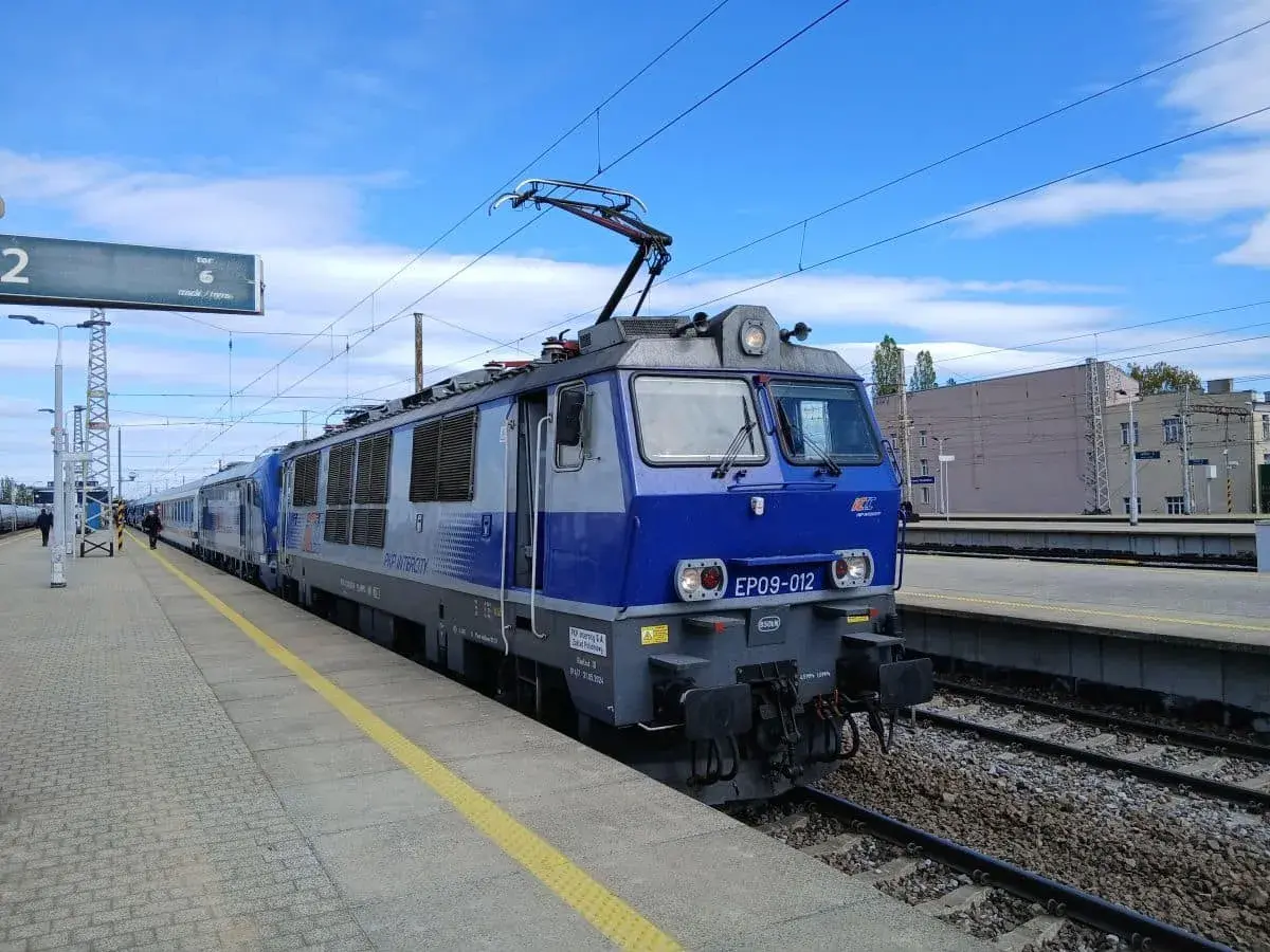 Niebieska lokomotywa PKP Intercity EP09-012 na torze, gotowa do podróży z Olsztyna do Wrocławia.