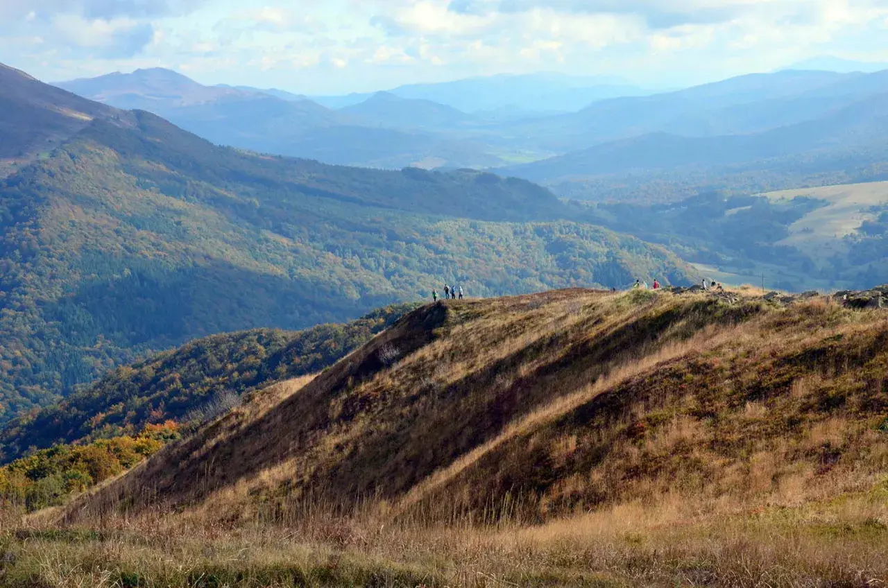Widok na Bieszczady Połonina Wetlińska. Grupa turystów podziwia jesienne krajobrazy górskie.