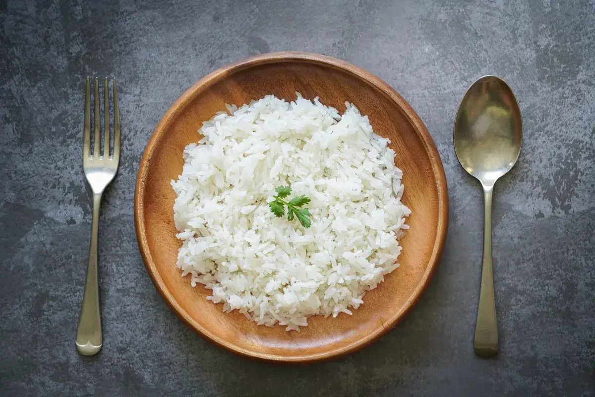 Piatto di riso bianco, forchetta e cucchiaio. Potrebbe essere l'inizio della dieta del riso 4 kg in 7 giorni.