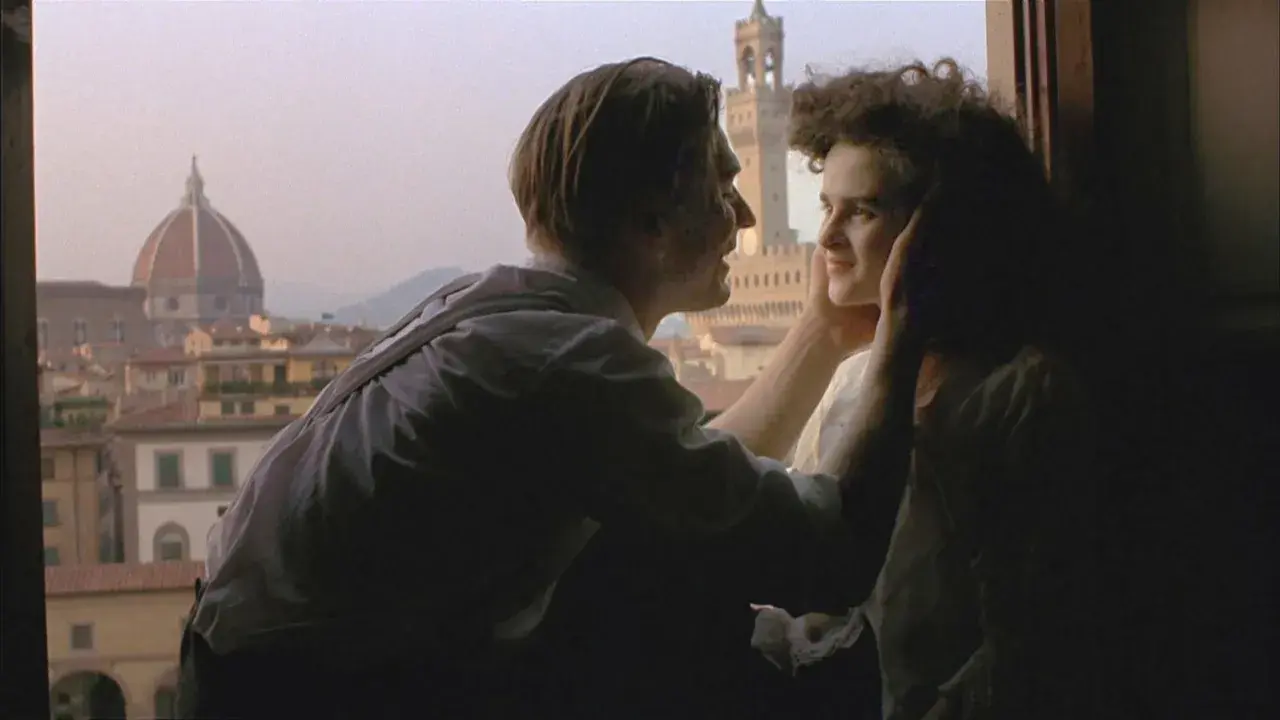 Ett par kysser varandra med Florens silhuett i bakgrunden, en ikonisk scen från en toscana film.