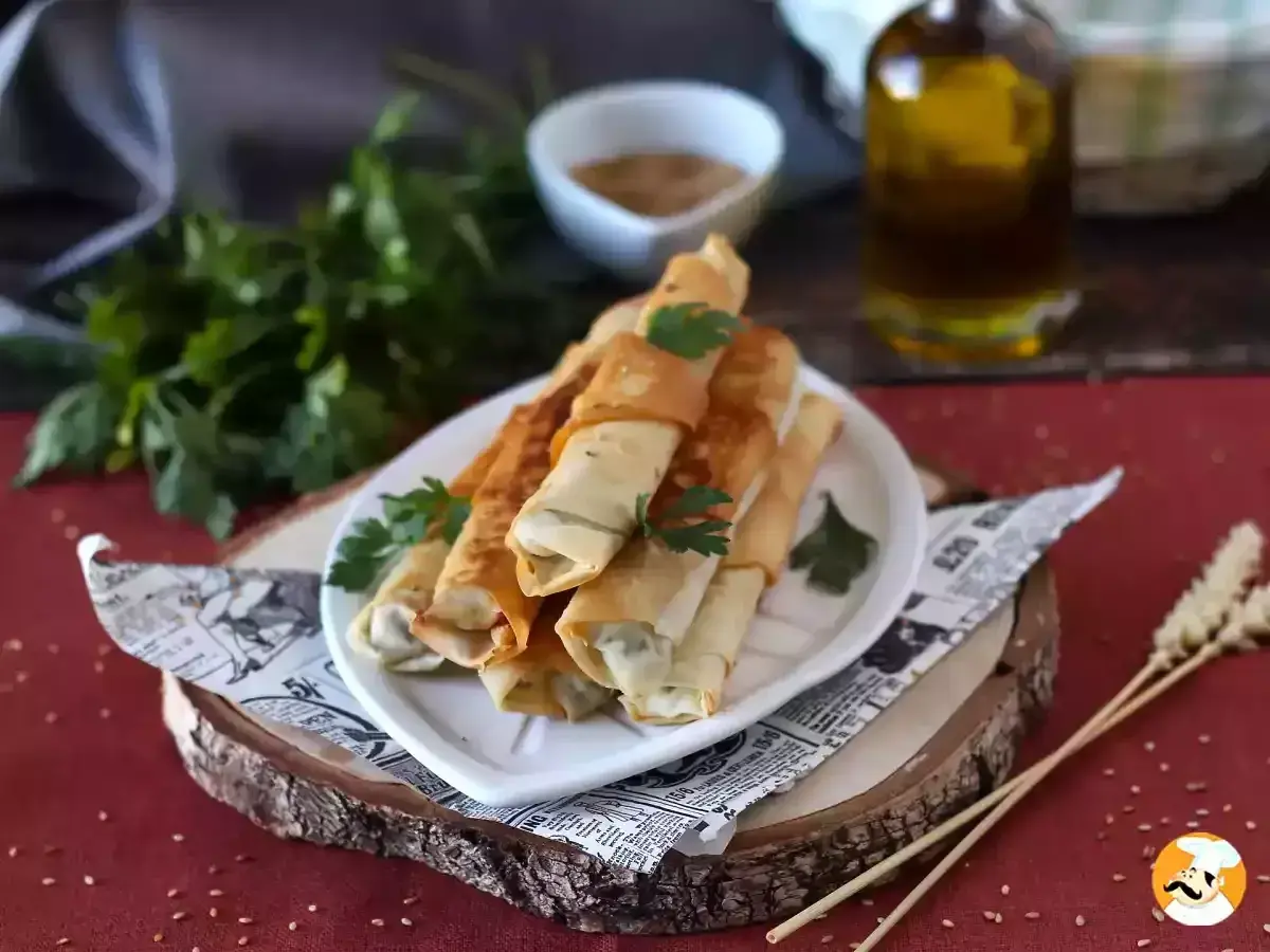 Rollitos crujientes de pasta filo rellenos, listos para disfrutar. Los ingredientes básicos para esta delicia son la pasta filo, un relleno sabroso y aceite.