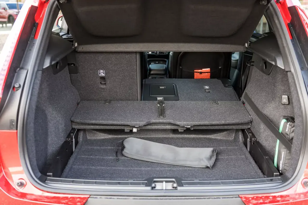 Bagagliaio aperto Volvo XC40, con sedili abbassati per massimizzare le volvo xc40 dimensioni. Si intravede un kit di pronto soccorso.