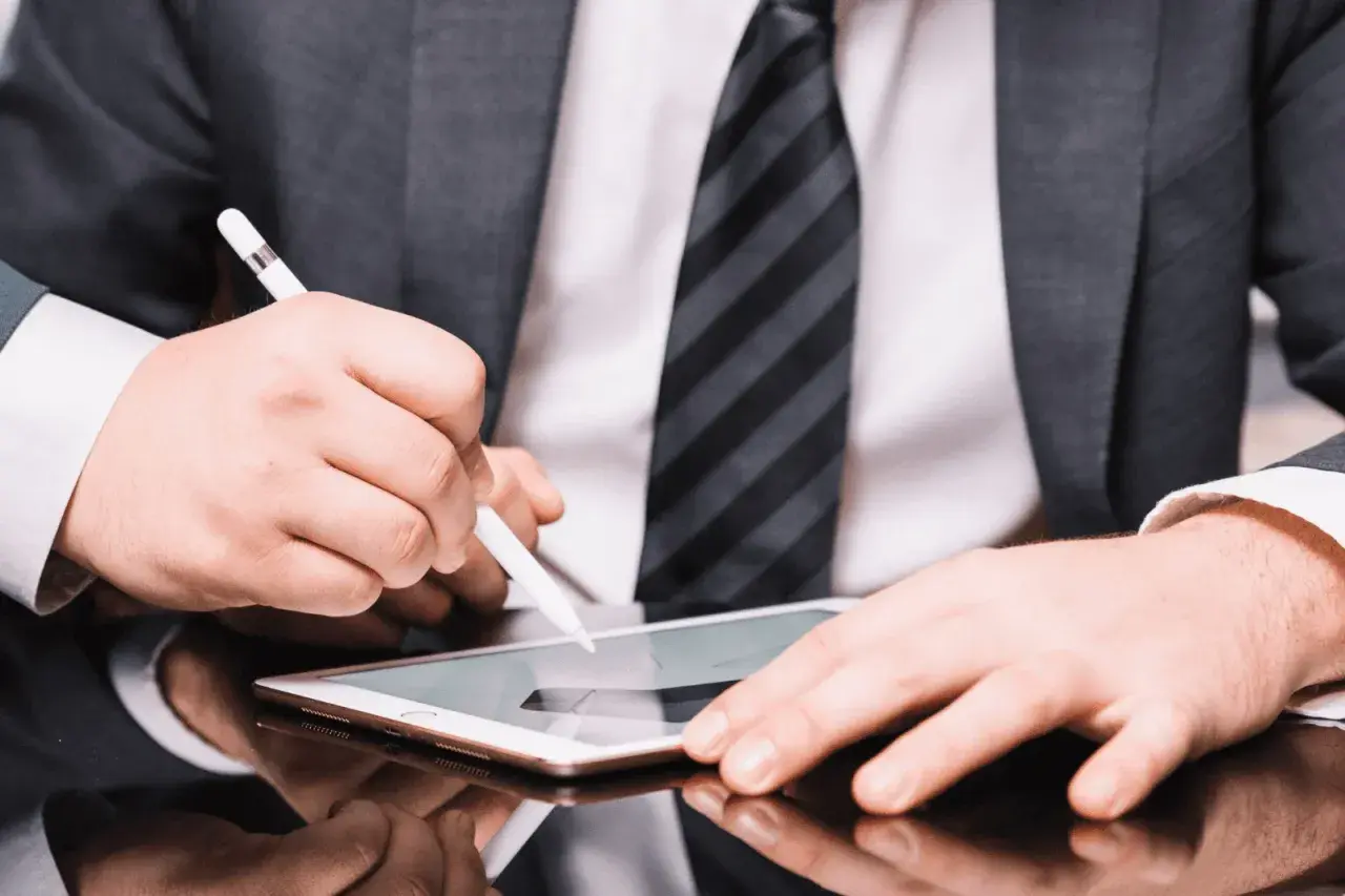 Hombre con traje firma un contrato con certificado digital en una tablet.