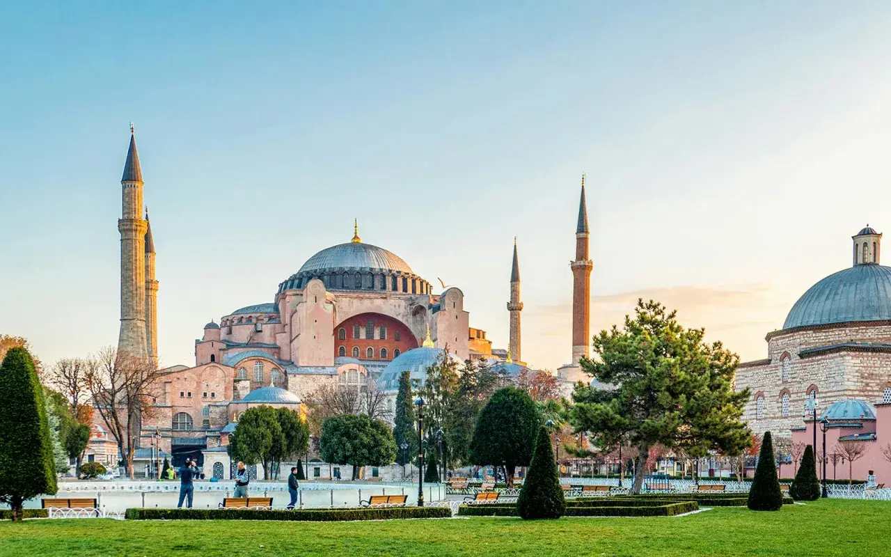 Majestatyczna Hagia Sophia w Stambule, z jej kopułą i minaretami, góruje nad zielonym parkiem.
