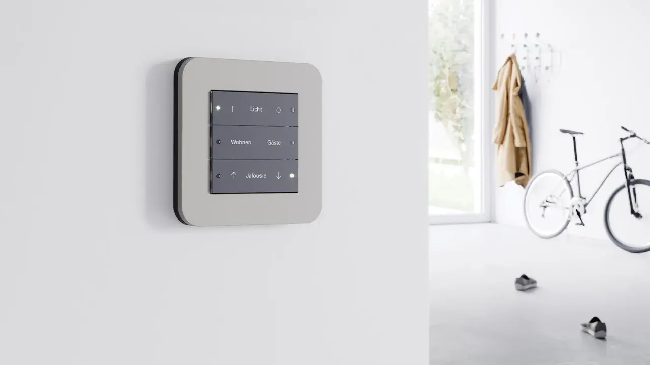Panel de control moderno con botones para luz, salón y persianas, parte de dispositivos KNX para automatización del hogar.