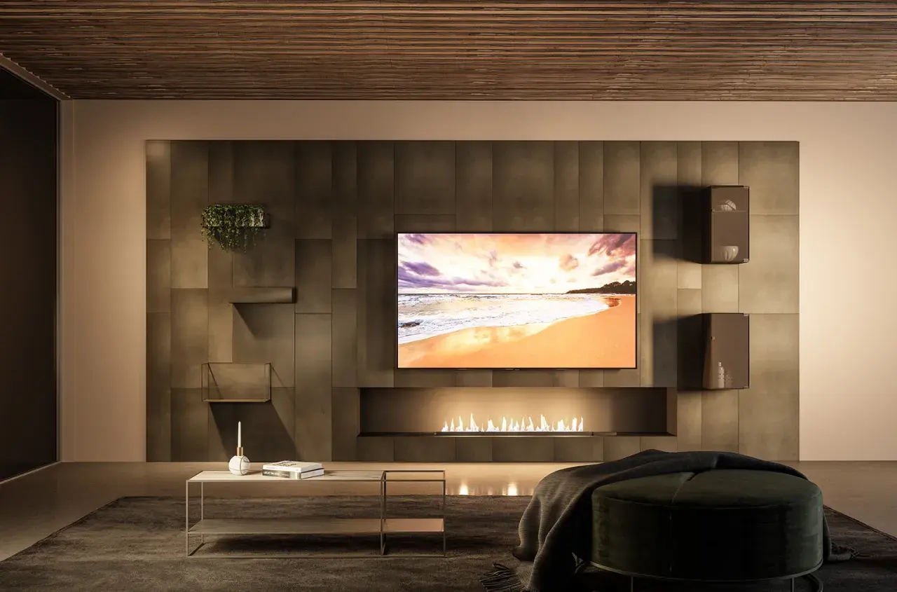 Un salon moderne avec une cheminée éthanol, une TV affichant une plage et une **déco derrière télé** minimaliste avec des étagères et une plante.
