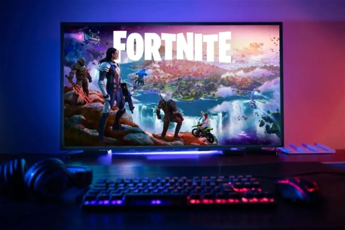 Écran affichant Fortnite avec des personnages, un clavier et une souris éclairés, prêt pour une configuration PC gaming.