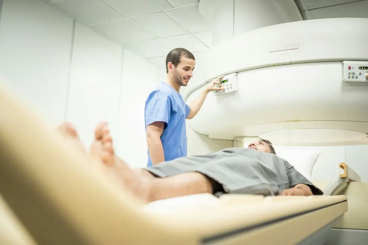 Un technicien ajuste les commandes d'un appareil d'IRM, prêt à examiner la prostate d'un patient allongé sur la table d'examen.