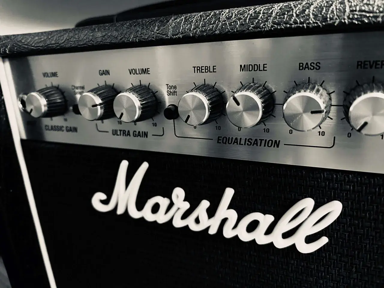 Gros plan sur le panneau de contrôle d'un ampli Marshall, avec les boutons de réglage du son (Volume, Gain, Treble, Middle, Bass) et le logo emblématique.