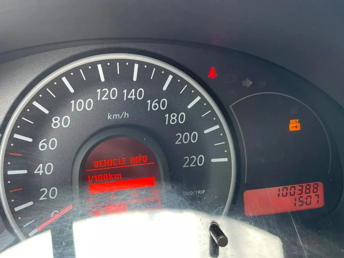 Kontrolki na desce rozdzielczej Nissan Micra: świeci się kontrolka kluczyka, wskazówka prędkościomierza na 0, a przebieg to 100388 km.