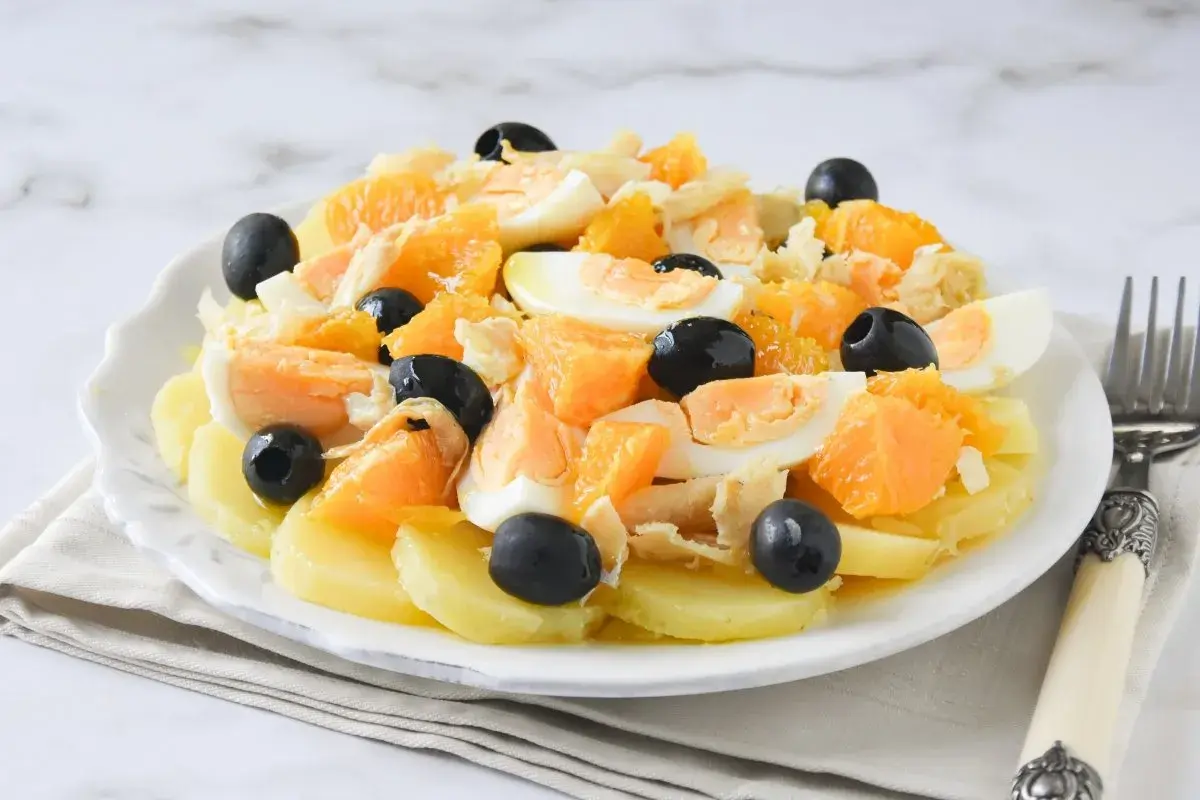 Ensalada malagueña con patatas, naranja, huevo duro, bacalao desmigado y aceitunas negras.