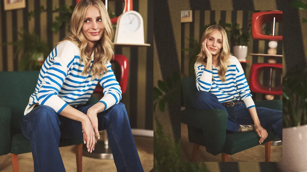 Blondynka w granatowych jeansach i pasiastym swetrze. Inspiracja, co ubrać do jeansów, by wyglądać stylowo i swobodnie.