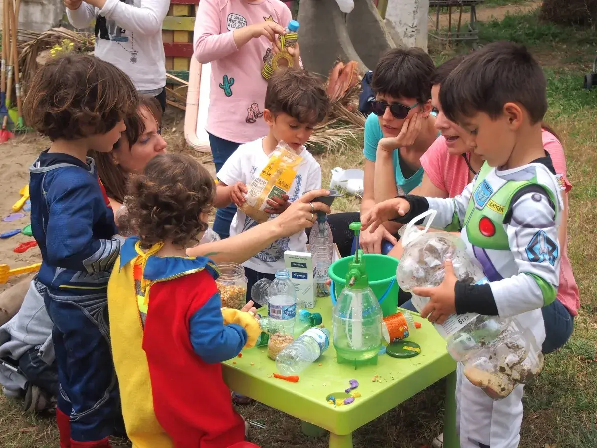 Niños disfrutan de actividades infantiles al aire libre, jugando con materiales reciclados y aprendiendo.