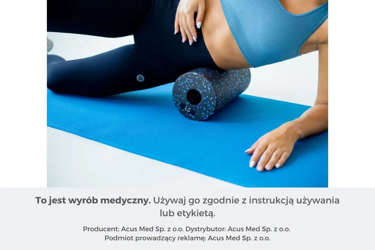 Kobieta używa rollera z wypustkami do masażu mięśni na niebieskiej macie.