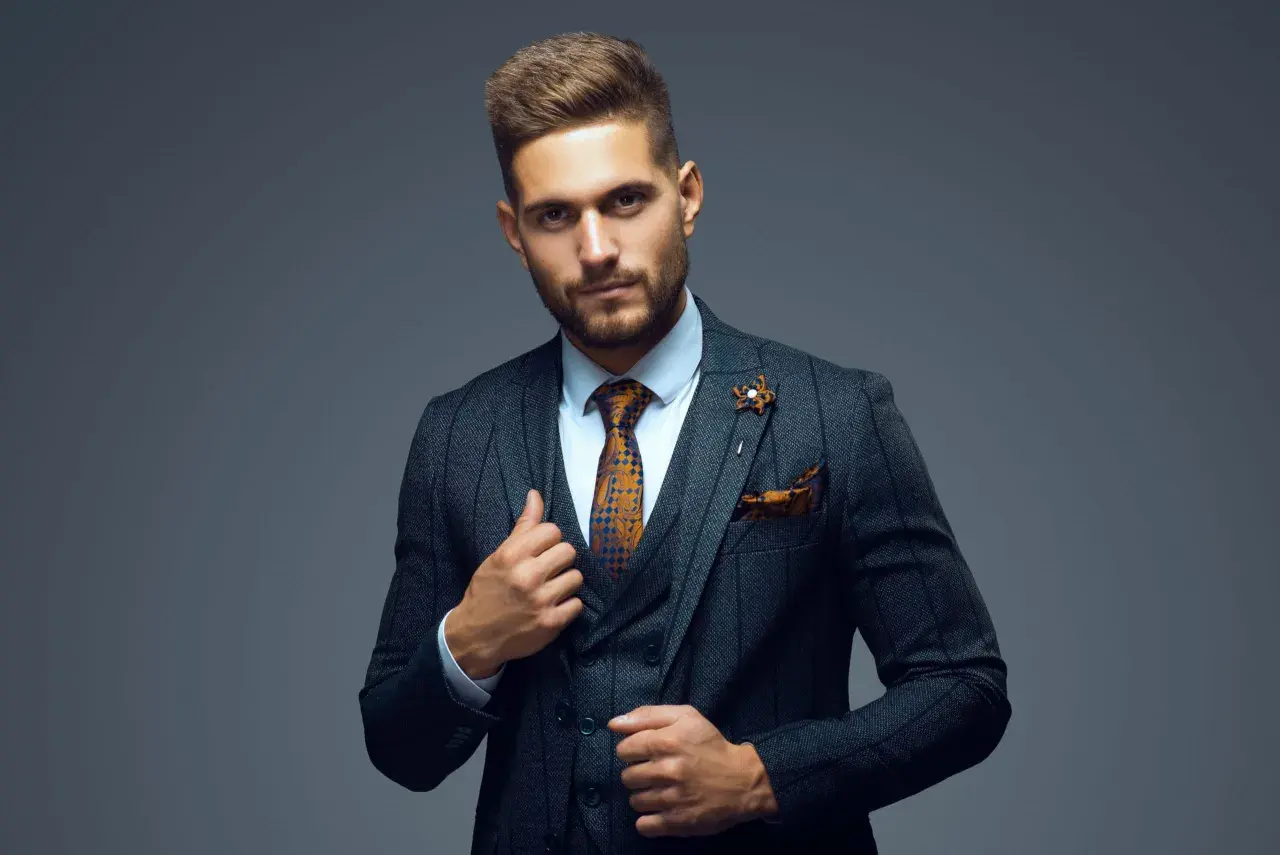Stilvoller Mann im Anzug mit gemustertem Hemd, Krawatte und Einstecktuch. Perfekt, um sich ein Outfit zusammenstellen zu lassen.