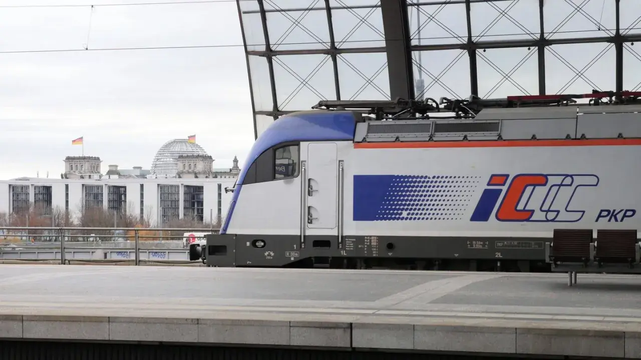 PKP Intercity Zug mit dem Logo "IC" und "PKP" steht am Bahnsteig. Im Hintergrund das Reichstagsgebäude in Berlin. Neue Zugverbindung Berlin - Krakau.